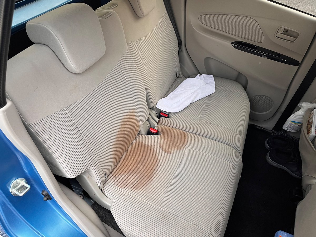 日産 デイズの後部座席。座面と背もたれに茶色いシミが広がっている（洗浄前）